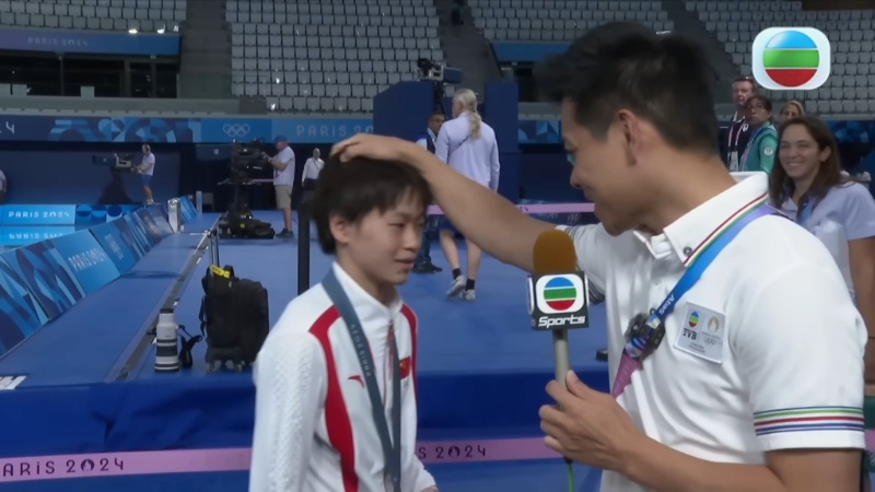 全紅嬋起初有點緊張，結束訪問后，何沖又摸摸小師妹的頭讓她放松。