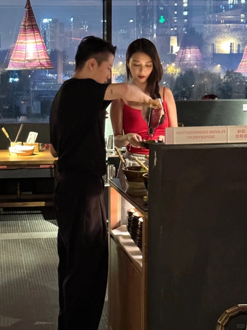 黑衣男溫柔地幫薛凱琪倒醬料。