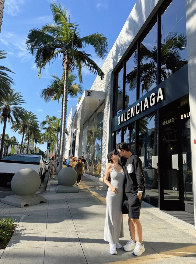 高鈞賢與女友在街頭甜蜜咀嘴，他女友皮膚非常白皙且身材高?。她身穿灰色貼身吊帶連身裙配白波鞋，用了右手遮肚凸凸的肚子，中指更戴上疑似定婚戒指，孕味濃。