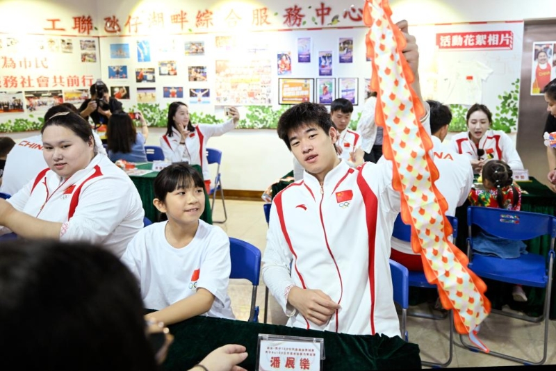 9月2日，在澳門工聯氹仔湖畔綜合服務中心，游泳運動員潘展樂（右）展示與小朋友一起制作的燈籠。新華社發