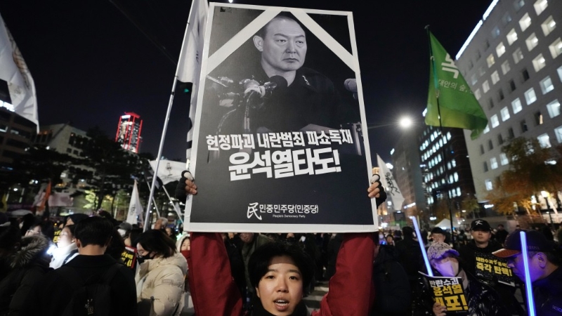 示威民眾高舉“推翻叛亂罪犯尹錫悅”的抗議海報。