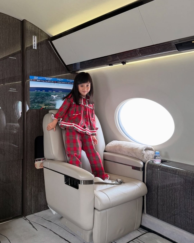 女兒在私人飛機上企上座椅。