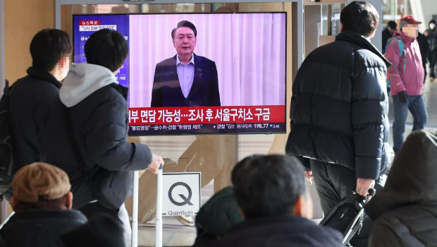 首爾車站的民眾觀看尹錫悅被捕的電視新聞報導。