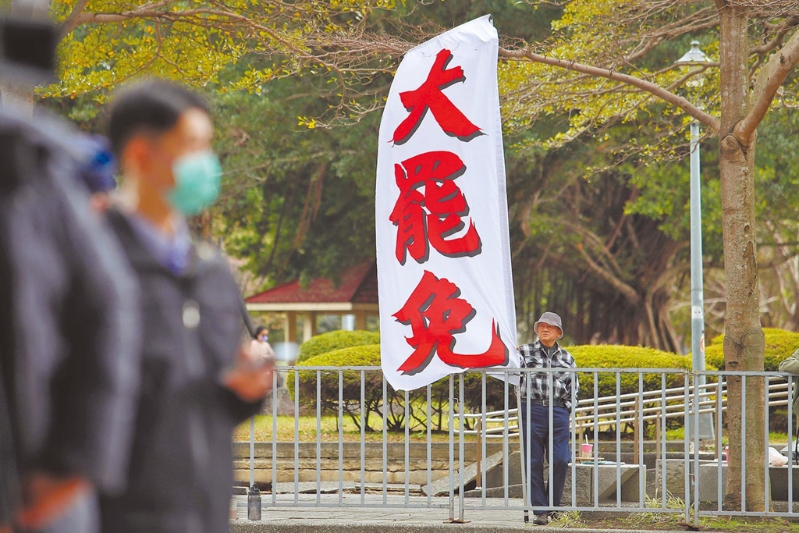 圖為民進黨2月5日召開會議，民眾在中央黨部樓下高舉旗幟，要求黨主席賴清德對大罷免表態。