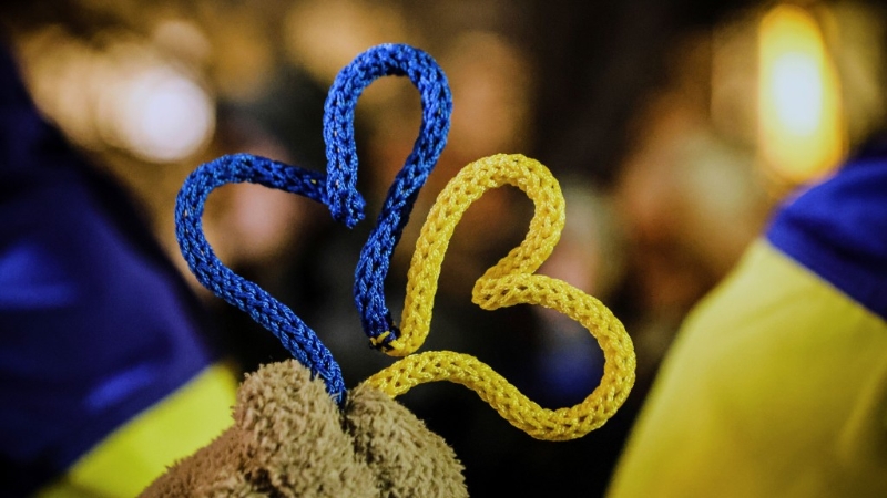 示威者手持烏克蘭國旗顏色的心聲援烏克蘭人。美聯社