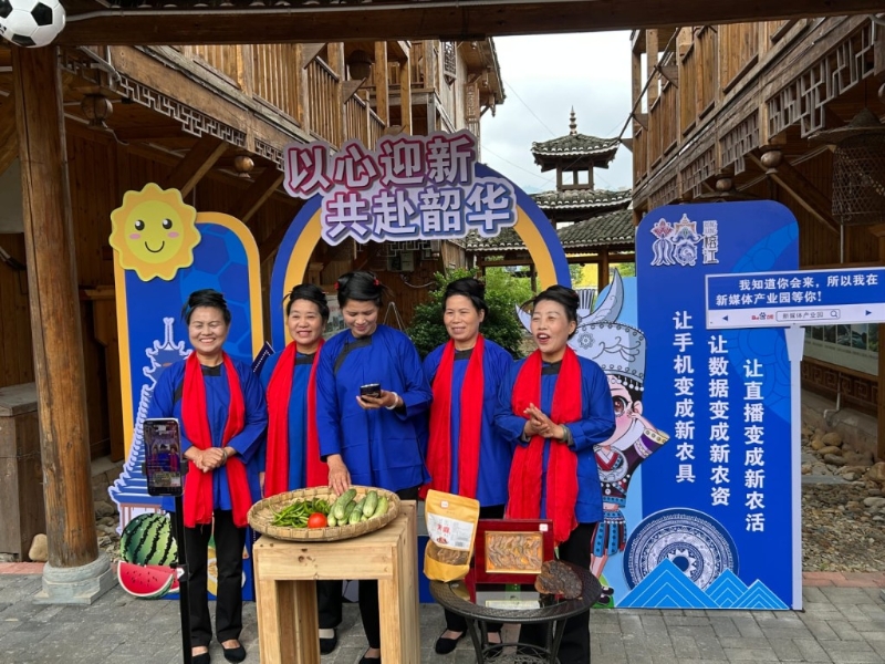 在新媒體產業園，一群穿著侗族服裝的中年婦女唱著侗歌直播帶貨。