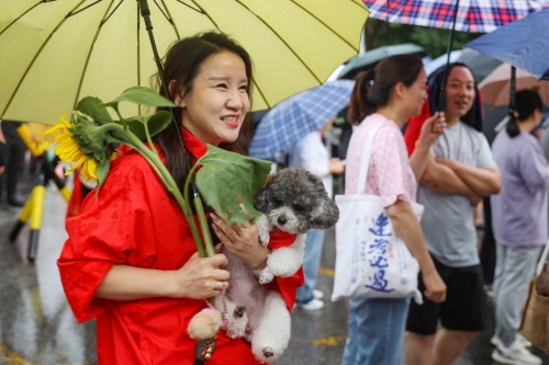 南京的家長帶向日葵送考望“一舉奪魁”。 中新社