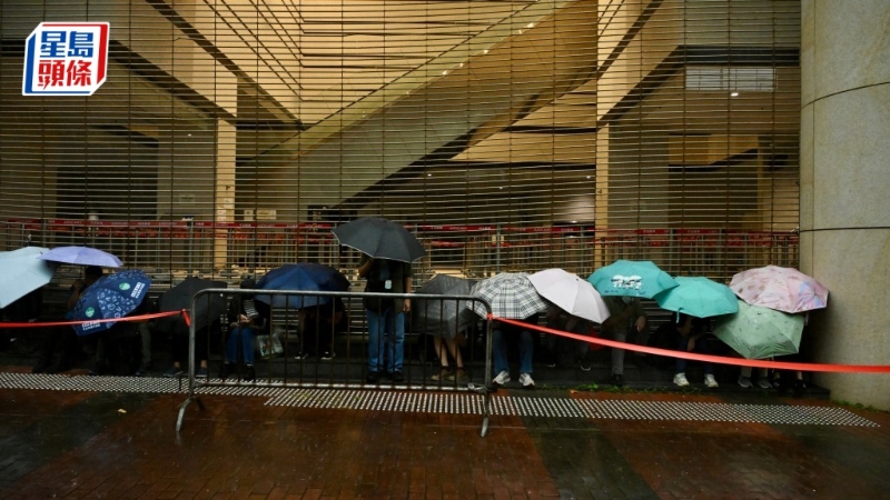 有近百名市民排隊，躲在法院外有瓦遮頭處。