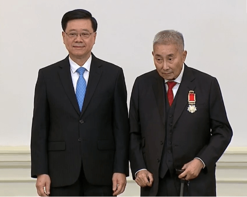 李家超向梁智仁頒發大紫荊勛章。