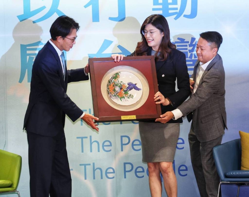 國民黨主席鄭麗文（中）19日與民眾黨主席黃國昌（左）進行“鄭黃會”，鄭麗文送上禮物給黃國昌。